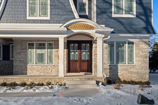 snow covered property entrance featuring french doors