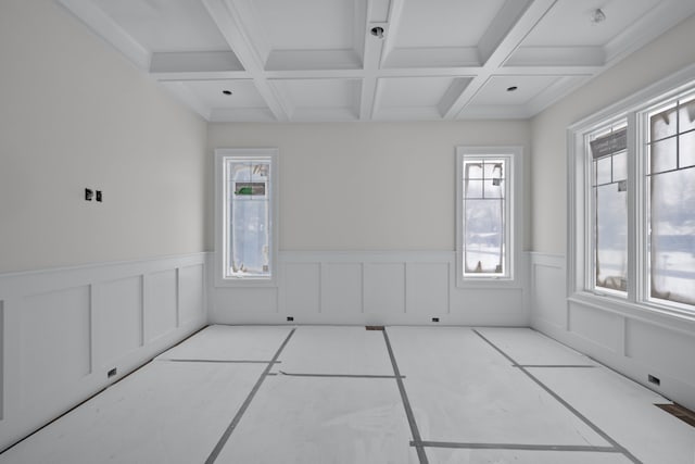 unfurnished room featuring plenty of natural light, beamed ceiling, and coffered ceiling