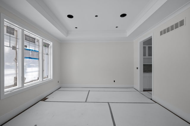 unfurnished room featuring light tile patterned floors, a tray ceiling, and ornamental molding