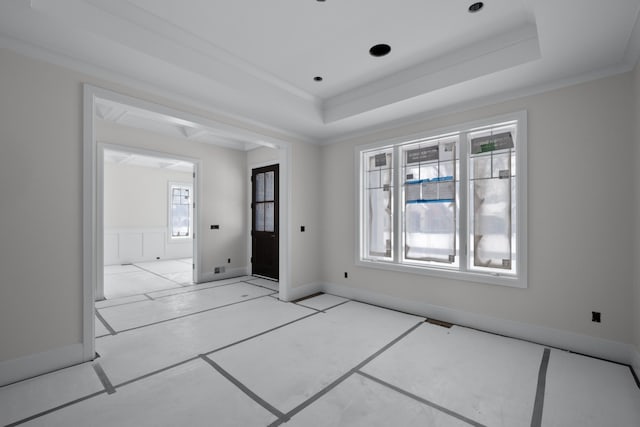 tiled empty room with a raised ceiling, a healthy amount of sunlight, and crown molding