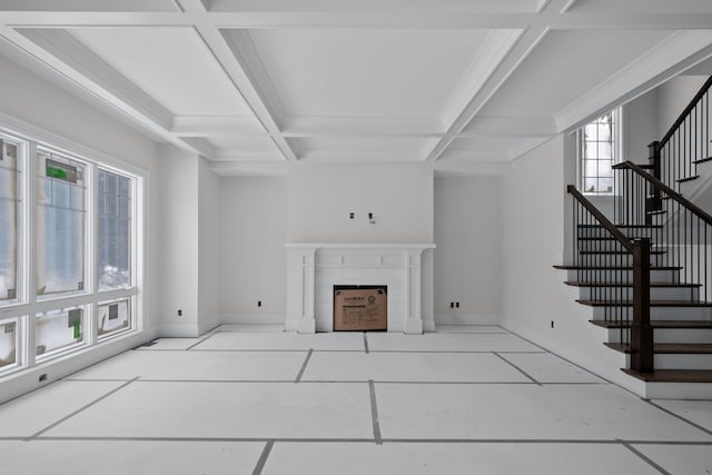 living room with beam ceiling, a tile fireplace, coffered ceiling, and light tile patterned flooring