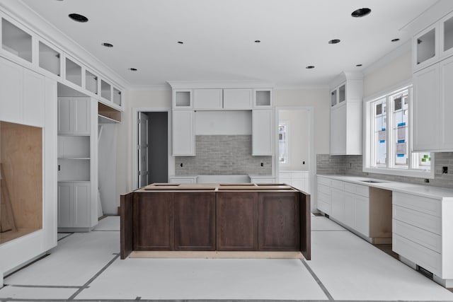 kitchen featuring white cabinets, backsplash, and ornamental molding