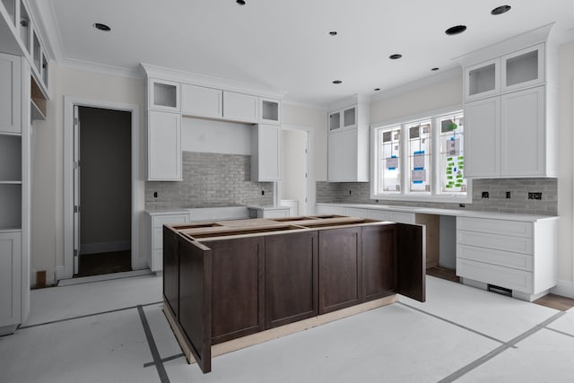 kitchen with decorative backsplash, crown molding, white cabinetry, and a kitchen island