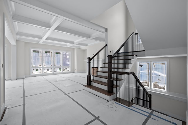 foyer with beam ceiling, plenty of natural light, and coffered ceiling