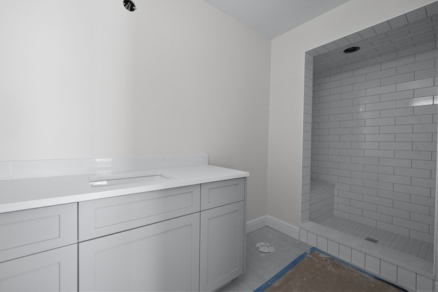 bathroom featuring tiled shower and sink