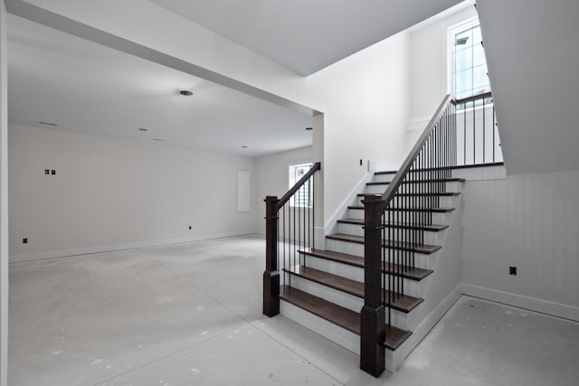 stairs featuring concrete flooring