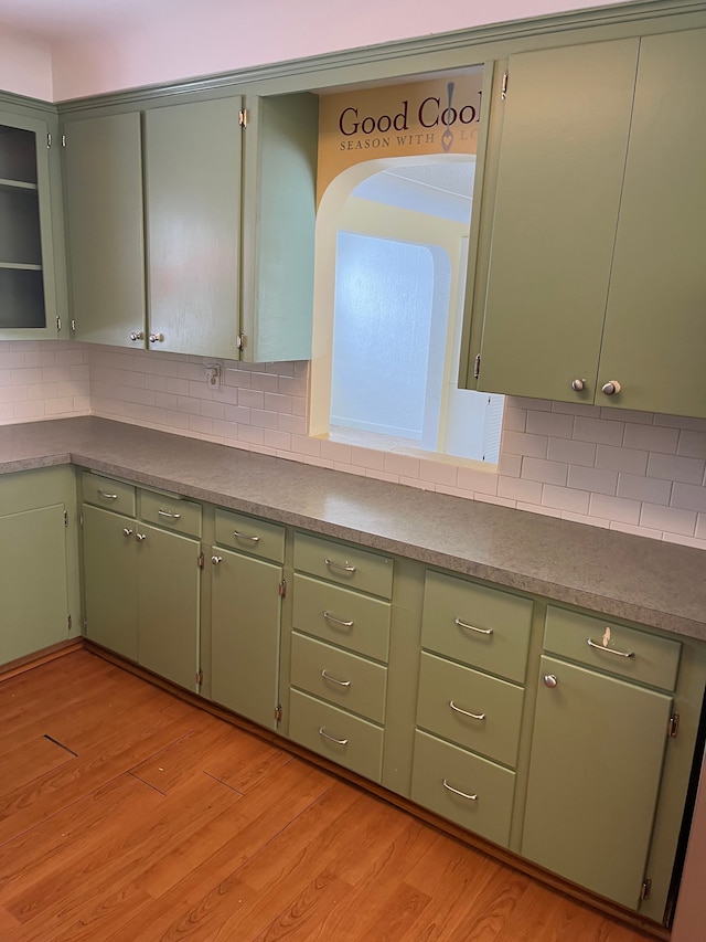 kitchen with light wood-type flooring and backsplash