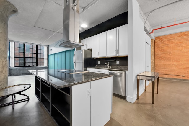 kitchen with brick wall, white cabinets, a center island, island exhaust hood, and stainless steel appliances