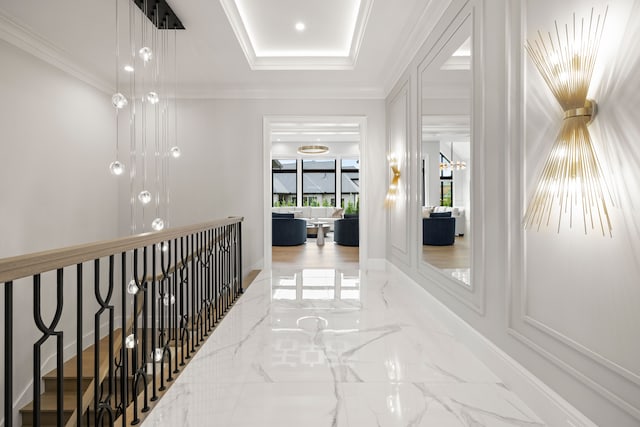 corridor with a raised ceiling and crown molding