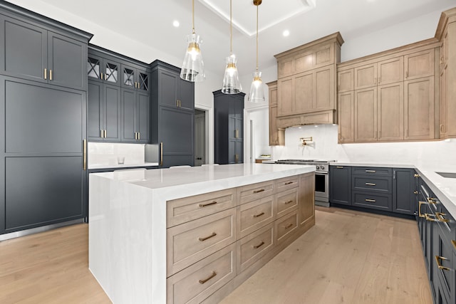 kitchen featuring gray cabinetry, decorative light fixtures, a kitchen island, high end range, and light brown cabinetry