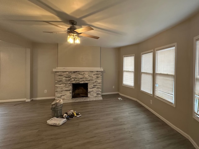 unfurnished living room featuring a fireplace, dark hardwood / wood-style floors, and ceiling fan