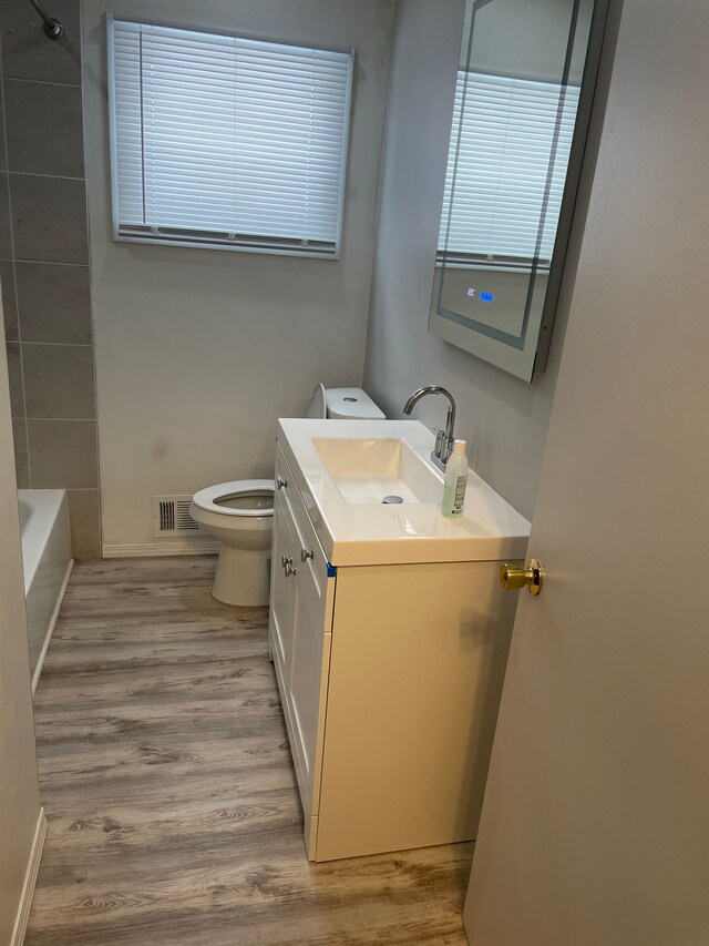 bathroom with toilet, vanity, and hardwood / wood-style floors