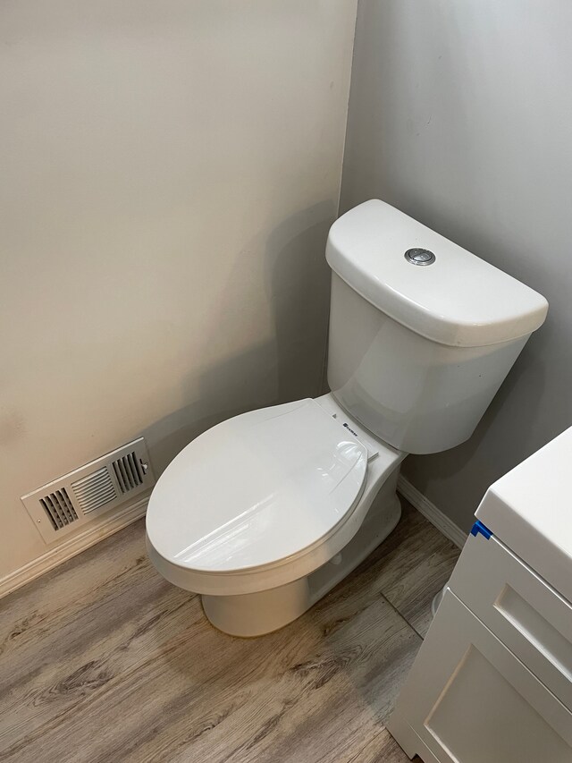 bathroom with toilet and hardwood / wood-style flooring