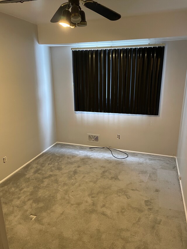 carpeted empty room featuring ceiling fan