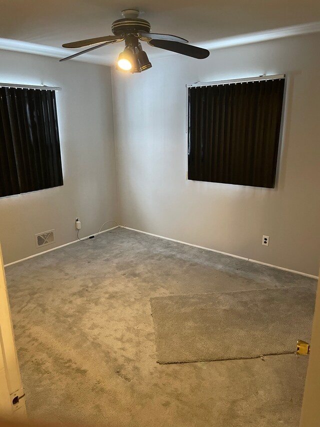 carpeted empty room featuring ceiling fan