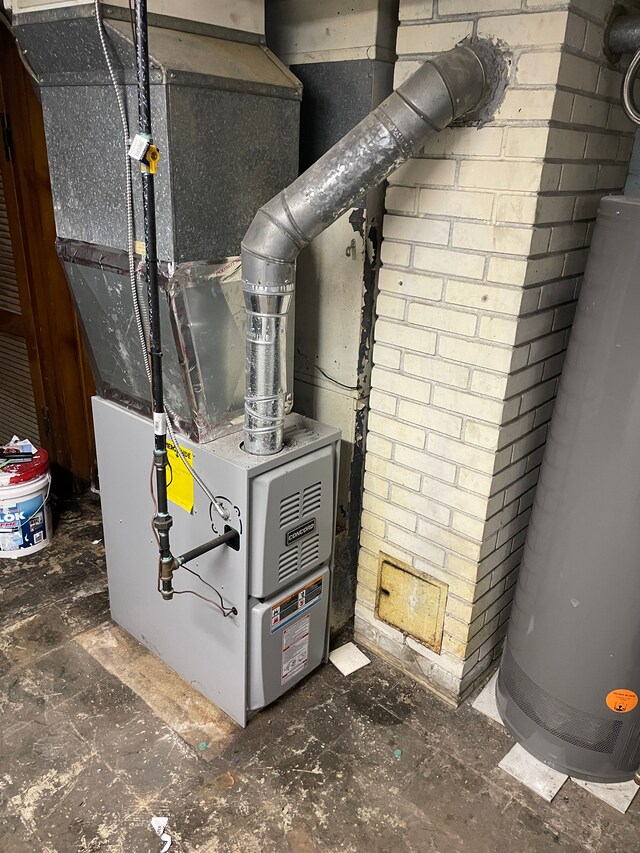 utility room featuring water heater and heating unit