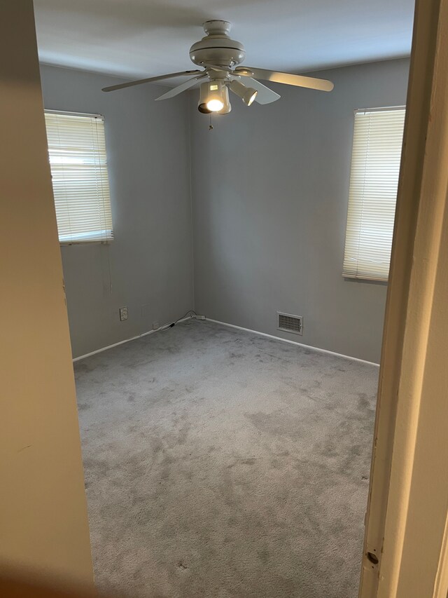 spare room featuring ceiling fan and light colored carpet