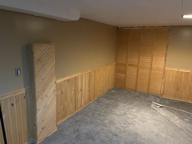 spare room featuring carpet floors and wooden walls