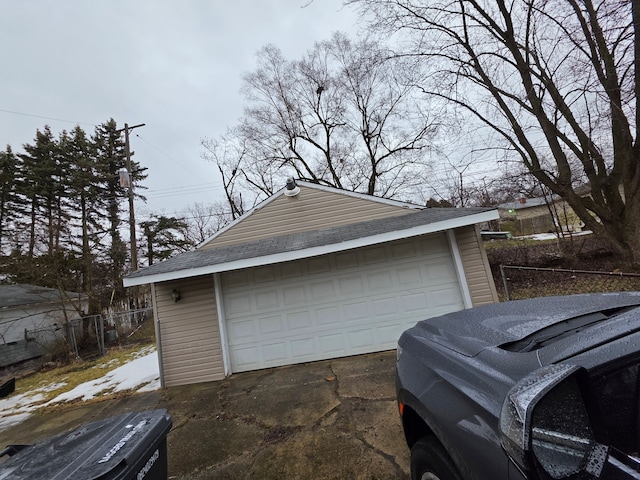 detached garage featuring fence