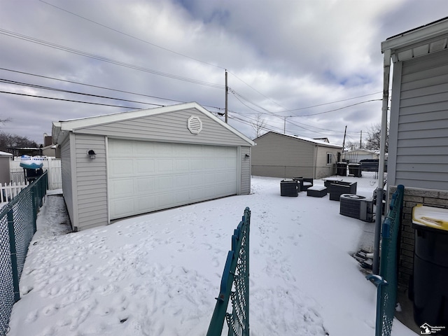 snow covered garage with central AC unit