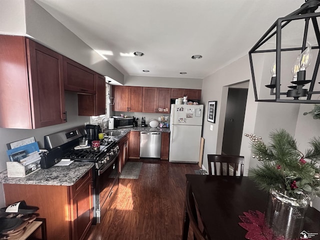 kitchen featuring sink, dark hardwood / wood-style floors, dark stone countertops, and stainless steel appliances