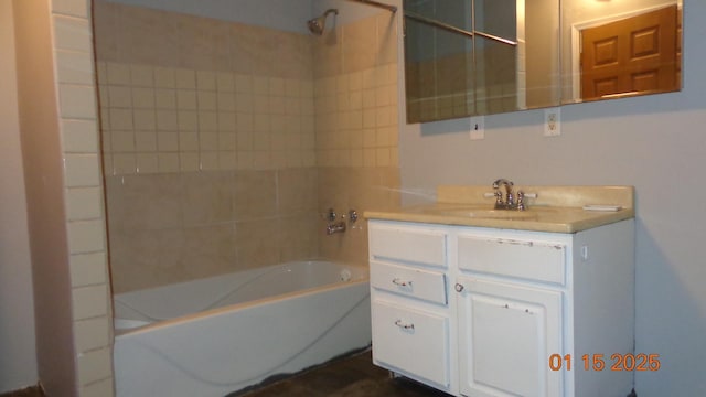 bathroom with tiled shower / bath and vanity