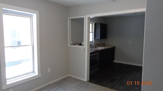 kitchen featuring black range with electric stovetop, sink, and dark carpet