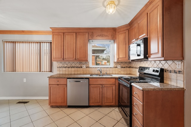 kitchen with sink, black appliances, light tile patterned floors, light stone countertops, and backsplash