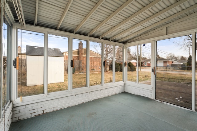 unfurnished sunroom featuring vaulted ceiling