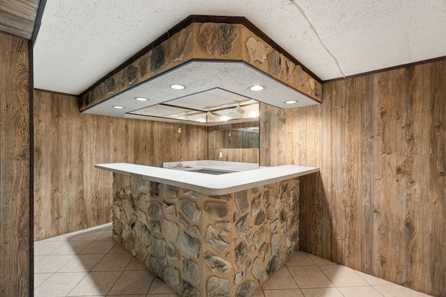 bar featuring light tile patterned floors and wood walls