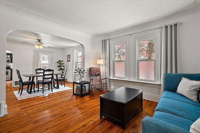 living room featuring ceiling fan and dark hardwood / wood-style flooring