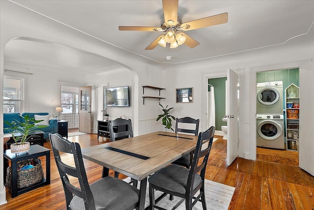 dining space with ceiling fan, dark hardwood / wood-style flooring, and stacked washer and clothes dryer