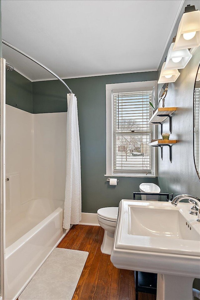 full bathroom with hardwood / wood-style flooring, sink, toilet, and shower / bathtub combination with curtain