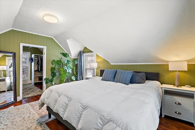 bedroom featuring dark hardwood / wood-style flooring, lofted ceiling, and wood walls