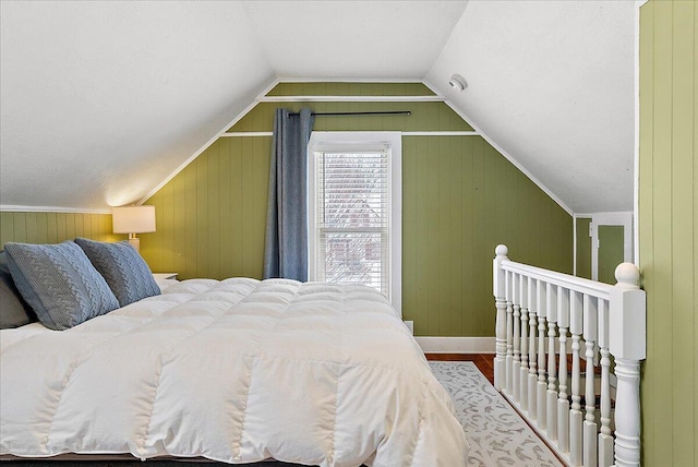 bedroom with wood-type flooring, lofted ceiling, and wood walls