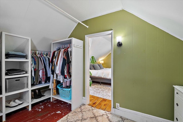 walk in closet featuring dark hardwood / wood-style flooring and vaulted ceiling