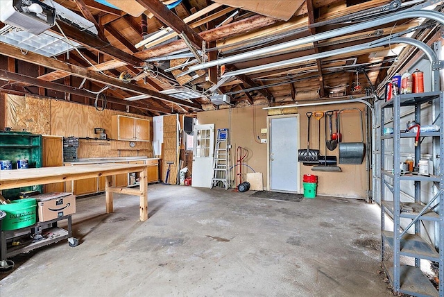 garage with a workshop area and a garage door opener