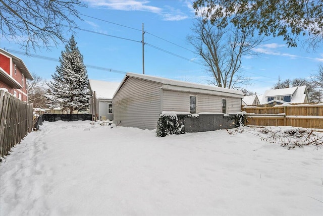 view of snow covered back of property