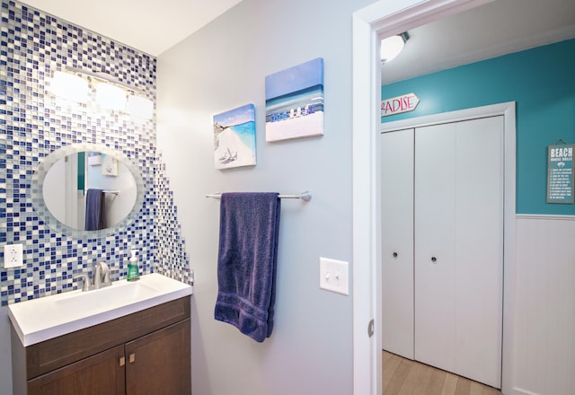 bathroom with hardwood / wood-style flooring, vanity, and tasteful backsplash