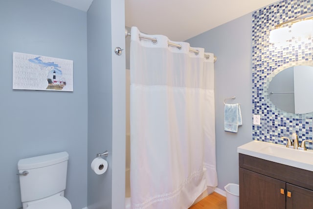 bathroom featuring hardwood / wood-style flooring, vanity, a shower with shower curtain, and tasteful backsplash