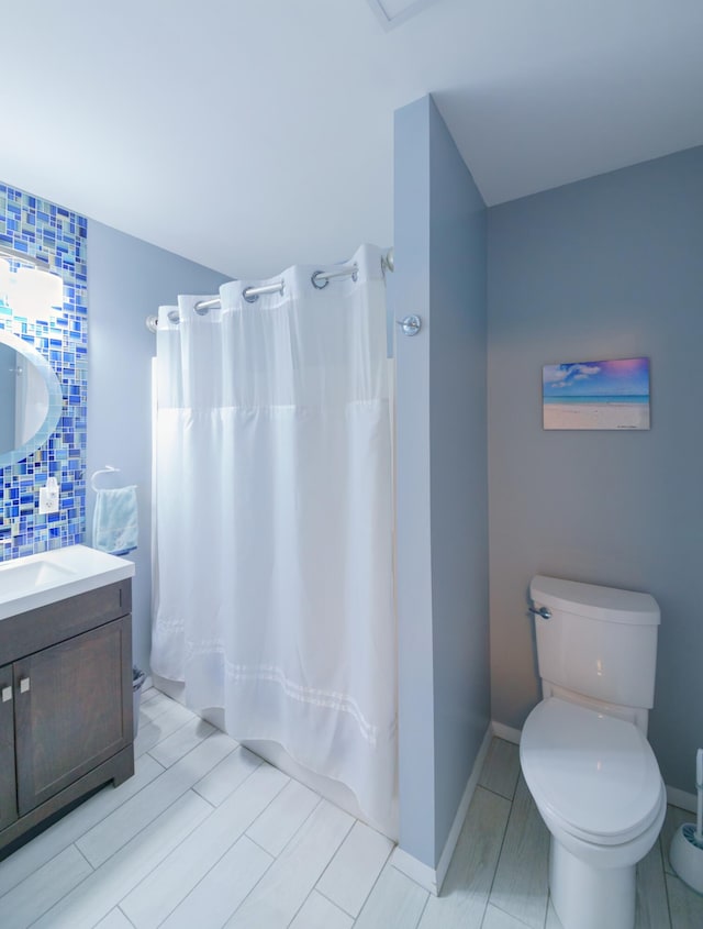 bathroom with backsplash, toilet, vanity, and a shower with curtain