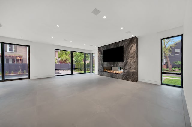 unfurnished living room featuring a large fireplace and concrete flooring