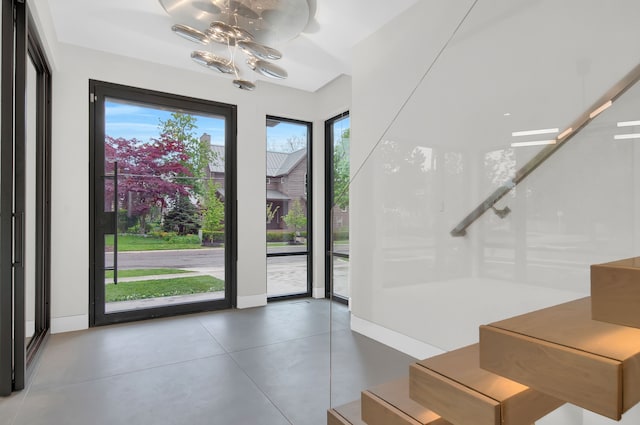 entryway featuring concrete floors and a chandelier