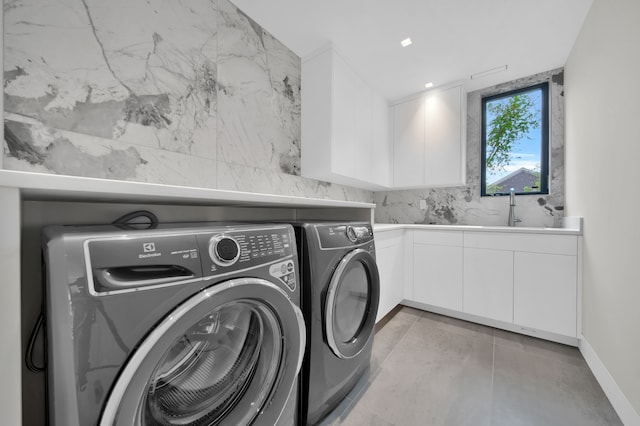 washroom featuring cabinets, independent washer and dryer, and sink