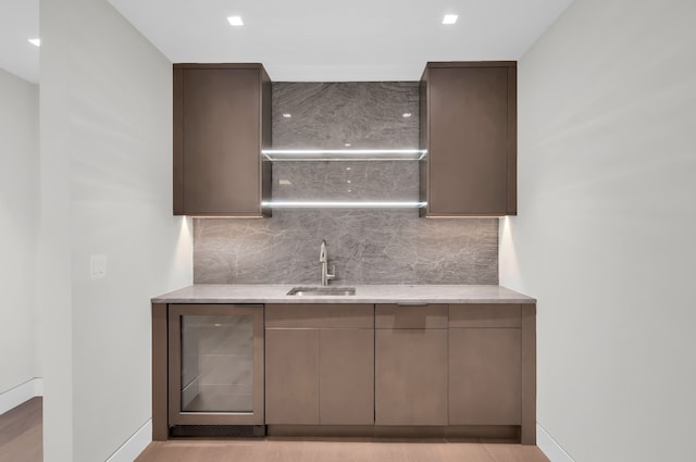 kitchen featuring beverage cooler, backsplash, and sink