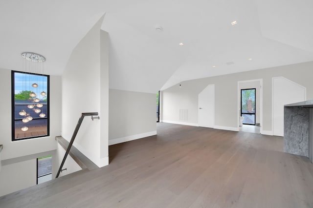 bonus room featuring lofted ceiling, a chandelier, and hardwood / wood-style floors