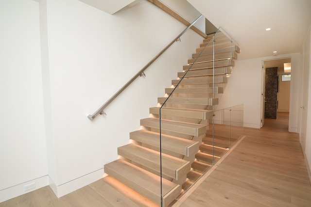 stairway with hardwood / wood-style flooring