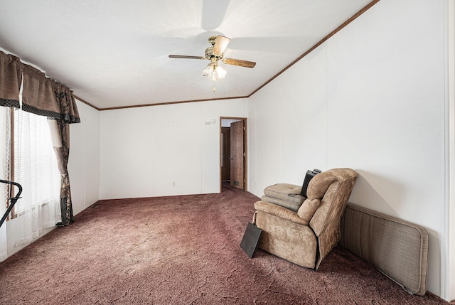 sitting room featuring ceiling fan, dark carpet, and crown molding