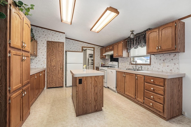 kitchen with crown molding, sink, white appliances, and a kitchen island