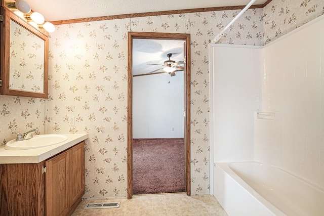 bathroom with a textured ceiling, vanity, ceiling fan, bathtub / shower combination, and crown molding